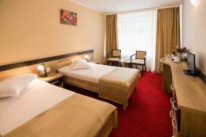 克利默内什蒂Complex Balnear Cozia的酒店客房,设有两张床,铺有红地毯。