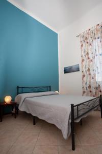 利沃诺Casa Dafne的一间卧室设有两张床和蓝色的墙壁