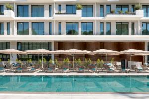 里斯本Martinhal Lisbon Oriente的酒店设有带椅子和遮阳伞的游泳池