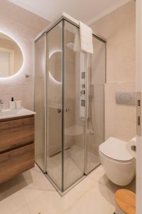 罗达Melena Premium Suites的带淋浴、卫生间和盥洗盆的浴室