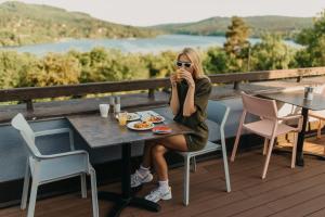 布尔诺OREA Resort Santon Brno的坐在桌子上吃甲板食物的女人