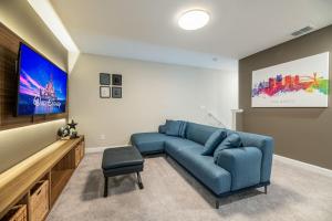 基西米Magical Disney Vacation Home - 5 bedrooms的客厅配有蓝色的沙发和平面电视。