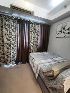 马尼拉马尼拉里斯@大海公寓的一间卧室配有床和带窗帘的窗户