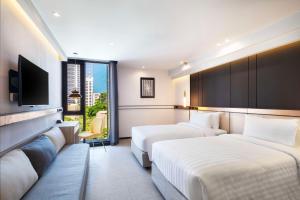 曼谷贝斯特韦斯特拉查达酒店的酒店客房设有两张床和一台平面电视。