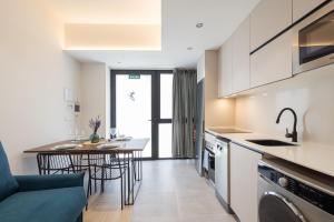 瓦伦西亚FLORIT FLATS - The Green Apartments的厨房以及带桌椅的起居室。