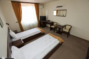 雷希察Hotel Dusan si Fiul Resita Sud的酒店客房配有两张床和一张书桌