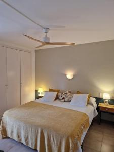 埃斯塔蒂特Acogedor apartamento en l'Estartit con piscina y Parking的一间卧室配有一张大床和吊扇