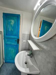 巴勒莫Mille Lire的浴室设有白色水槽和蓝色门。