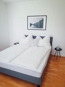 布莱堡Das Schmiedhofer in Bleiburg的一张带白色床单和枕头的床