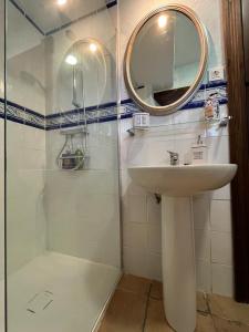 比努埃萨Casa Rural La Ferrería的浴室配有盥洗盆和带镜子的淋浴