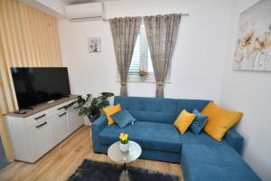 锡尼Palomino apartment的客厅配有蓝色的沙发和电视