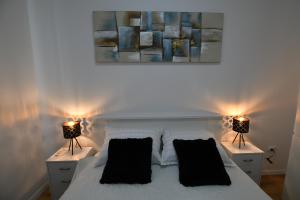 锡尼Palomino apartment的一间卧室配有一张白色的床,桌子上配有两盏灯