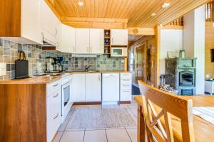 耶姆赛Himos Huili 1的一间厨房,配有白色家电和木制天花板