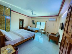 穆扎法拉巴德Kashmir Heaven Guest House的一间带两张床的卧室和一台电视