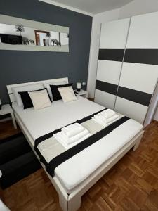诺瓦利娅Apartments Loncar-near Zrće beach的一间卧室配有一张黑白条纹大床