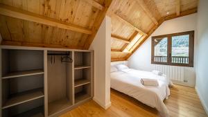 萨拉尔杜Aran Hostel的一间带两张床和木制天花板的卧室