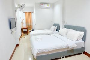 清刊โรงแรมบ้านครูตุ้ม เชียงคาน เลย Baankrutoom Hotel Chiangkhan Loei的一间酒店客房,设有两张床和电视