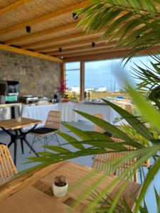 米克诺斯城Aegean Hospitality的一间带桌椅的用餐室和一间带窗户的房间