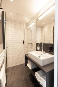 弗希塔ibis Styles Vechta的浴室配有白色水槽和淋浴。