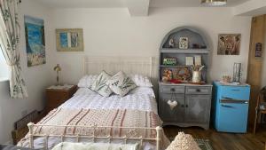 滨海索尔特本Wheelhouse - Grinkle Bell Cottage的一间卧室配有一张床和一个蓝色的橱柜