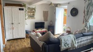 滨海索尔特本Wheelhouse - Grinkle Bell Cottage的客厅配有蓝色的沙发和电视