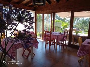 UdiasPosada Sel de Breno的一间带桌椅和窗户的用餐室