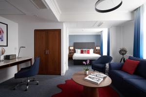 伦敦The Cumberland, London的客厅配有沙发和1张床