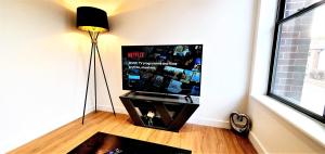 北安普敦Cliftonville Heights - 2 bed Home away from Home的客厅配有平面电视和台灯。