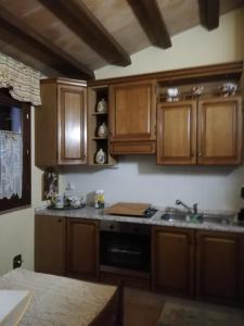 特雷维Casa Vacanze Torretta的厨房配有木制橱柜和炉灶烤箱。