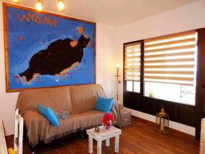 阿索马达Apartamento deluxe Betancort的客厅配有沙发和墙上的绘画