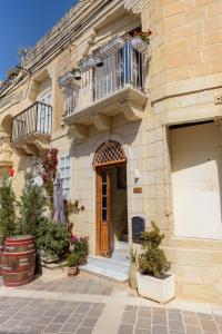 拉巴特Casa Deguara townhouse Rabat Malta的带阳台和木门的建筑