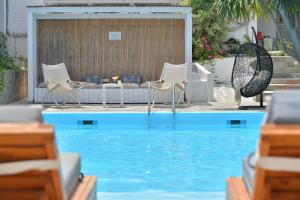 斯卡拉Aktaion Beach Boutique Hotel & Spa的一个带椅子和桌子及沙发的游泳池