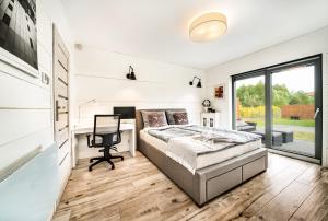 科沃布热格Domek hot tub jacuzzi Chillout的一间卧室配有一张床、一张书桌和一个窗户。