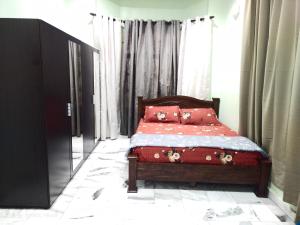 居林D' SHAM Homestay, Mslim Only的一间卧室配有一张带红色床单和枕头的床。