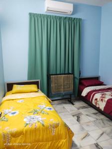 居林D' SHAM Homestay, Mslim Only的一间卧室配有黄色的床和绿色窗帘