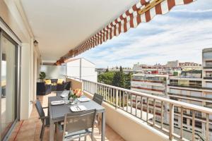 戛纳Cannes centre-Palais-200m des plages的设有一个配有桌椅并享有美景的阳台。