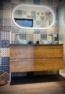 拉特斯特德布赫LA MAISON CACHEE-BA的浴室设有水槽和墙上的镜子
