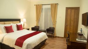 日惹格里亚维吉兰斯亚利亚酒店的酒店客房,配有一张床、一张桌子和椅子