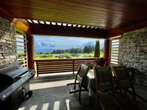 班斯科Pirin Golf Lake House的一个带桌椅的庭院和一个大窗户。