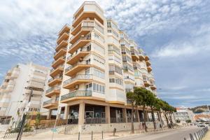 卡帕里卡海岸BeGuest Beachfront Apartment Caparica Lisbon的城市街道上一座高耸的公寓楼