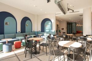 梅斯特MEININGER Venezia Mestre的餐厅设有桌椅和蓝色的墙壁