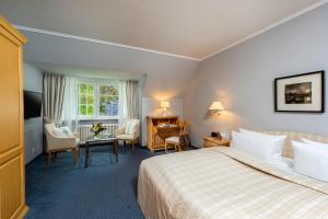 蒂门多弗施特兰德Landhaus Carstens的酒店客房带一张床、一张桌子和椅子