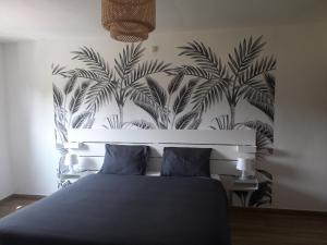 班什Veronique schouckens的一间卧室配有一张棕榈树壁画床