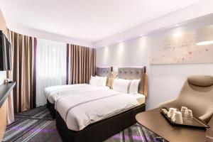 汉堡Premier Inn Hamburg City Hammerbrook的配有一张床和一把椅子的酒店客房