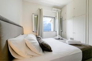 Agia Pelagia ChlomouGialos Holiday House的卧室配有一张大白色床和窗户
