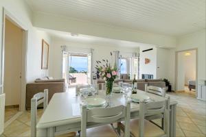 Agia Pelagia ChlomouGialos Holiday House的一间配备有白色桌椅的用餐室