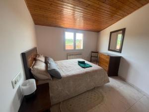 博伊罗Ático con magnifica terraza en Boiro的一间卧室设有一张床和木制天花板