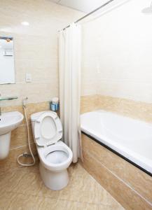 胡志明市Nguyen Thanh Hotel的浴室配有卫生间、盥洗盆和浴缸。