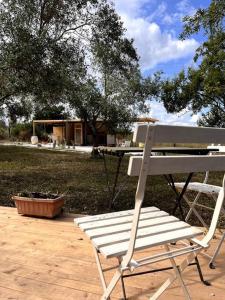 诺托La ViTa in land - between olives and almonds的一张白色长凳,坐在带桌子的庭院