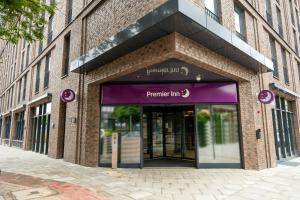 汉堡Premier Inn Hamburg City Klostertor的一座砖砌建筑,拥有通往停车场的紫色入口